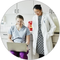Female nurse with female doctor in exam room