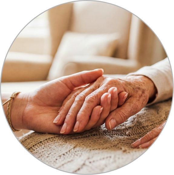 Close-up image of two people holding hands while sitting in a living room