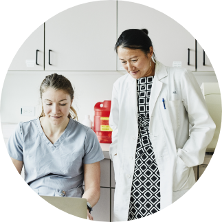 Female nurse with female doctor in exam room